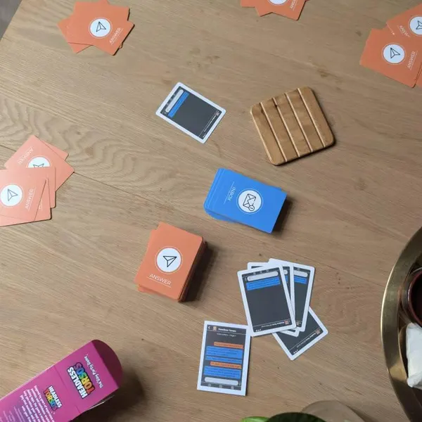 A game of Headless Torsos mid-round, with INBOX message cards and ANSWER cards spread across a wooden table
